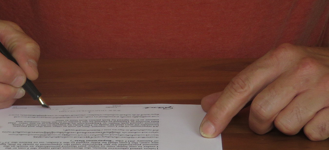 Expat signing a bilingual living will with a Thai doctor observing